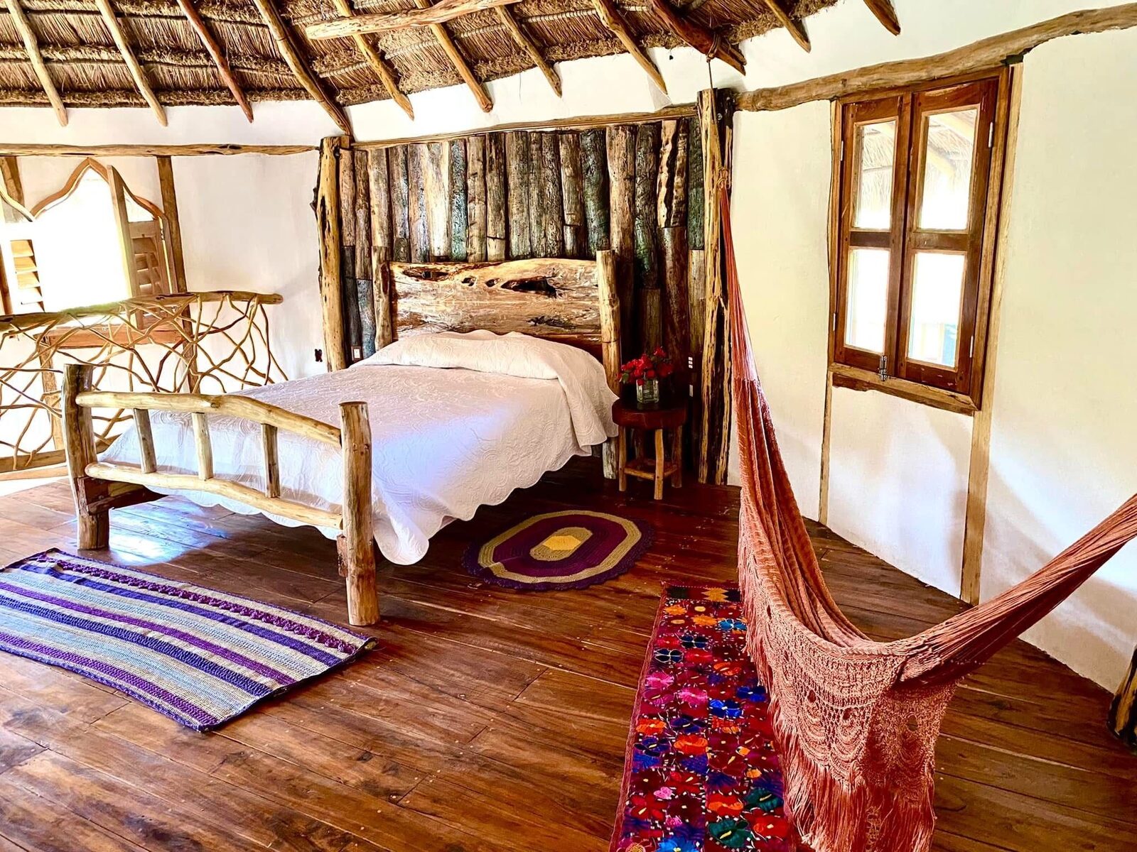 A bedroom dressed with handwoven rugs and earth-tone linens.