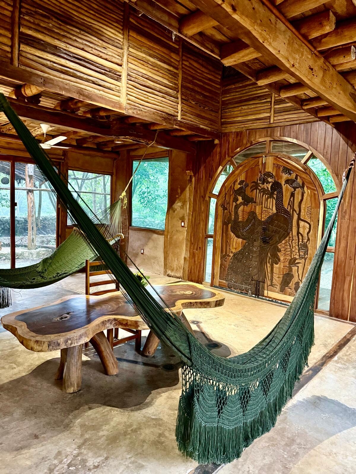 A common area with two hammocks and a painted peacock door.